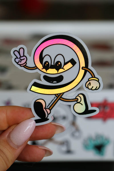 Cartoon character sticker held by a hand with a blurred background